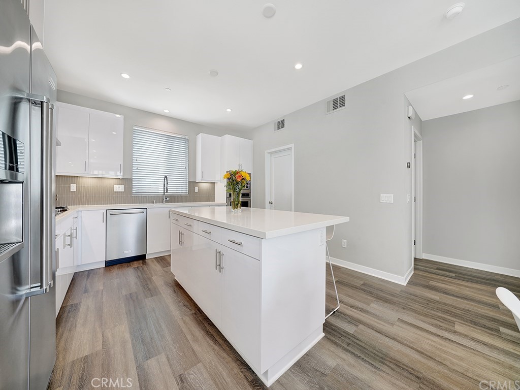 604 Malibu Costa Mesa, CA 92627 - Photo 7 of 40 a kitchen with white cabinets appliances and sink