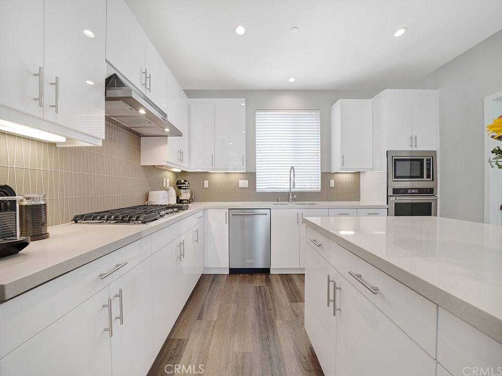 604 Malibu Costa Mesa, CA 92627 - Photo 8 of 40 a kitchen with granite countertop white cabinets and white appliances