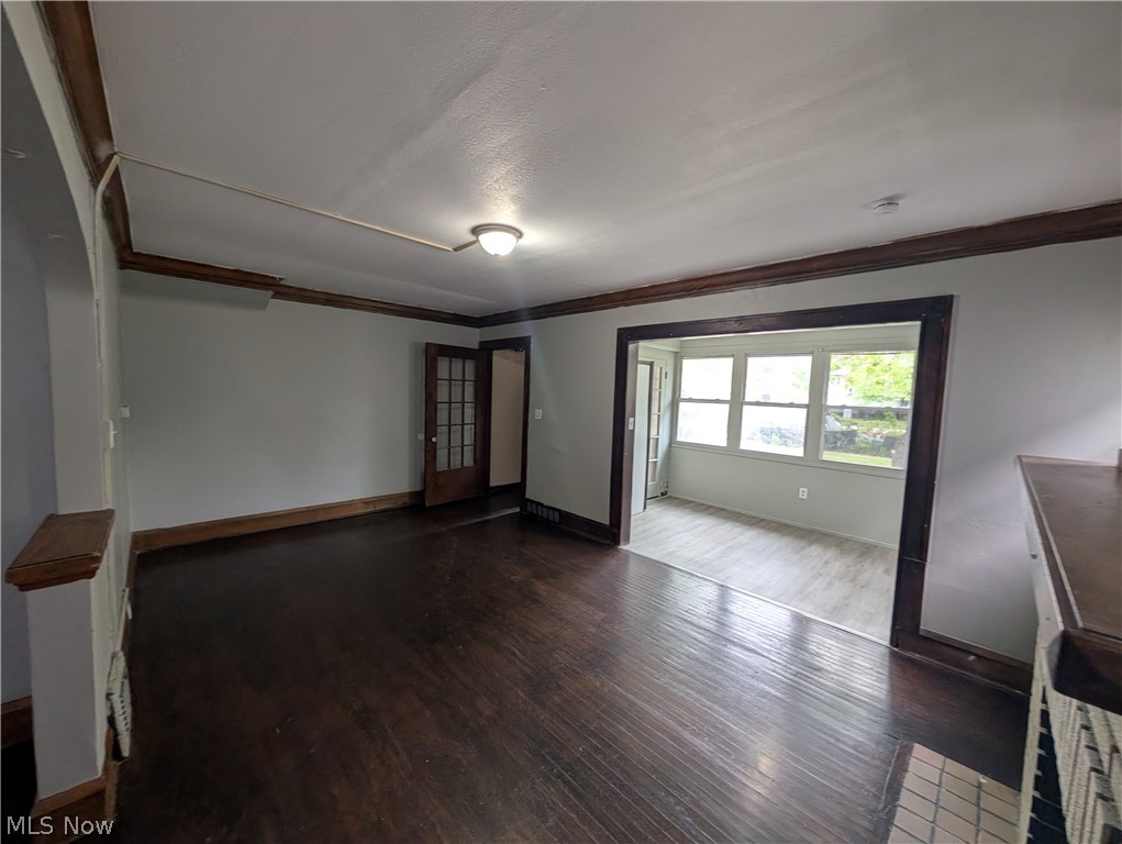 475 East 146th Street Cleveland, OH 44110 - Photo 5 of 28 Spacious room with dark wood-finish flooring, light-toned walls, and dark wood trim