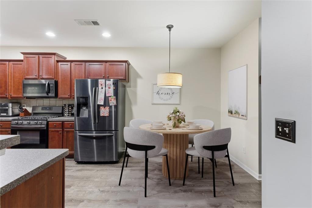 4349 Kousa Road, Unit 4 Austell, GA 30106 - Photo 9 of 43 a kitchen with stainless steel appliances a refrigerator a stove a sink a dining table and chairs