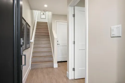a view of a hallway with wooden floor and entryway