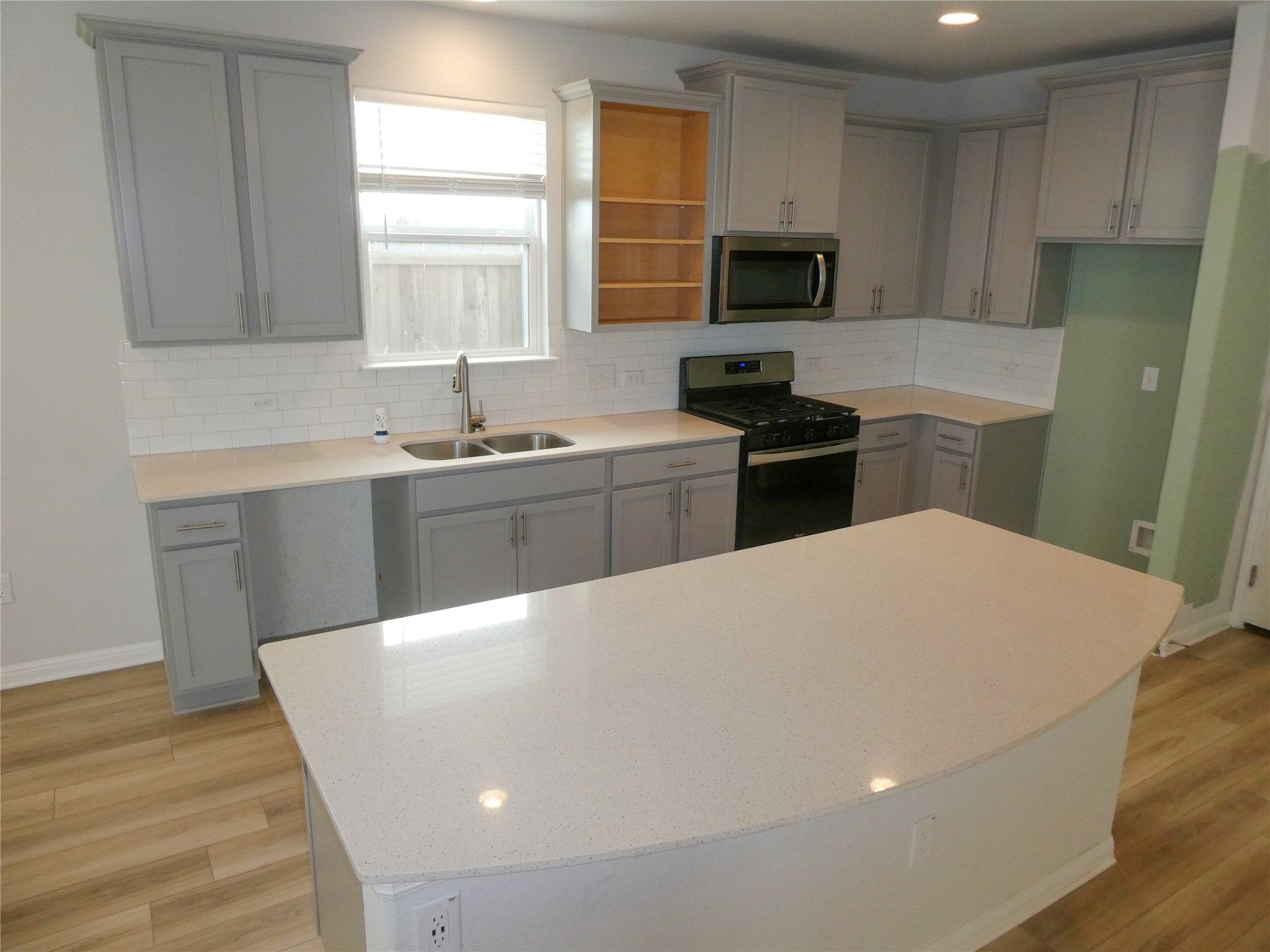 10906 Sentinel Drive Austin, TX 78747 - Photo 3 of 18 a kitchen with a stove a sink and a microwave