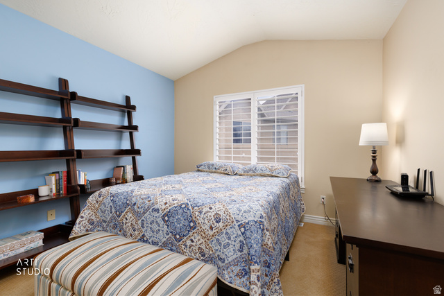 6761 950 East Midvale, UT 84047 - Photo 19 of 44 Vaulted ceiling room featuring a large window with white plantation shutters, a built-in wooden ladder-style shelving unit, and warm-toned carpeting