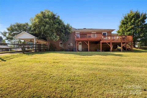 a view of a swimming pool with lawn chairs and plants