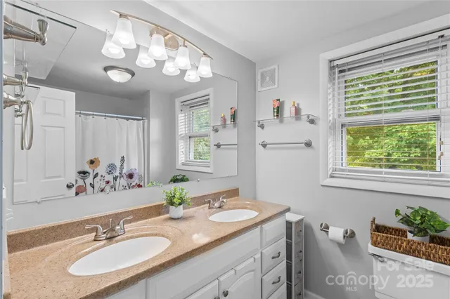 a bathroom with a granite countertop sink a large mirror and a window