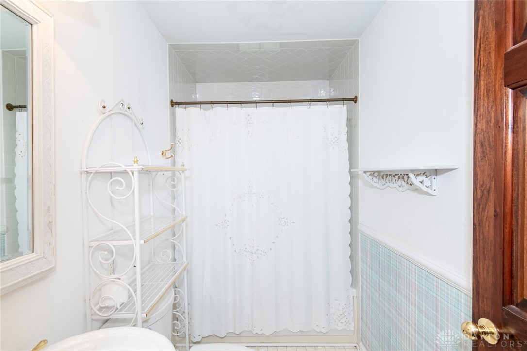 9981 Ridge Acres Lane Englewood, OH 45322 - Photo 24 of 73 This bright bathroom features classic white tile and a functional shower area.