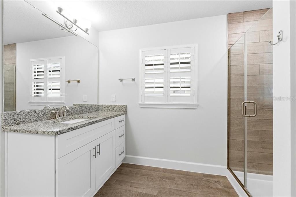 331 Cres Ridge Road Auburndale, FL 33823 - Photo 37 of 63 a bathroom with a granite countertop sink a mirror and a shower