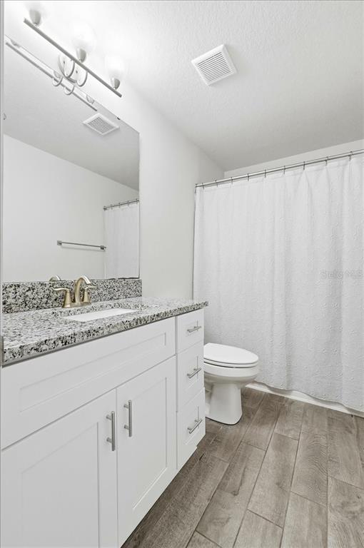 331 Cres Ridge Road Auburndale, FL 33823 - Photo 43 of 63 a bathroom with a granite countertop sink a toilet and a shower