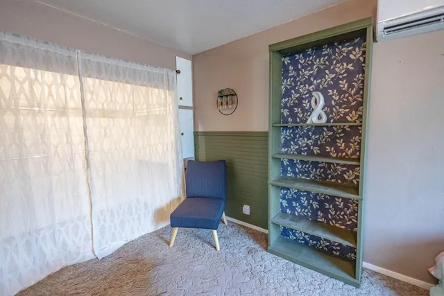 a view of a bedroom with furniture and a window