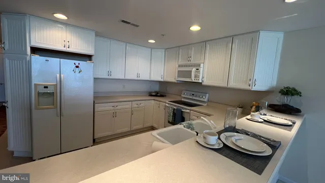 a kitchen with stainless steel appliances granite countertop a refrigerator sink and cabinets