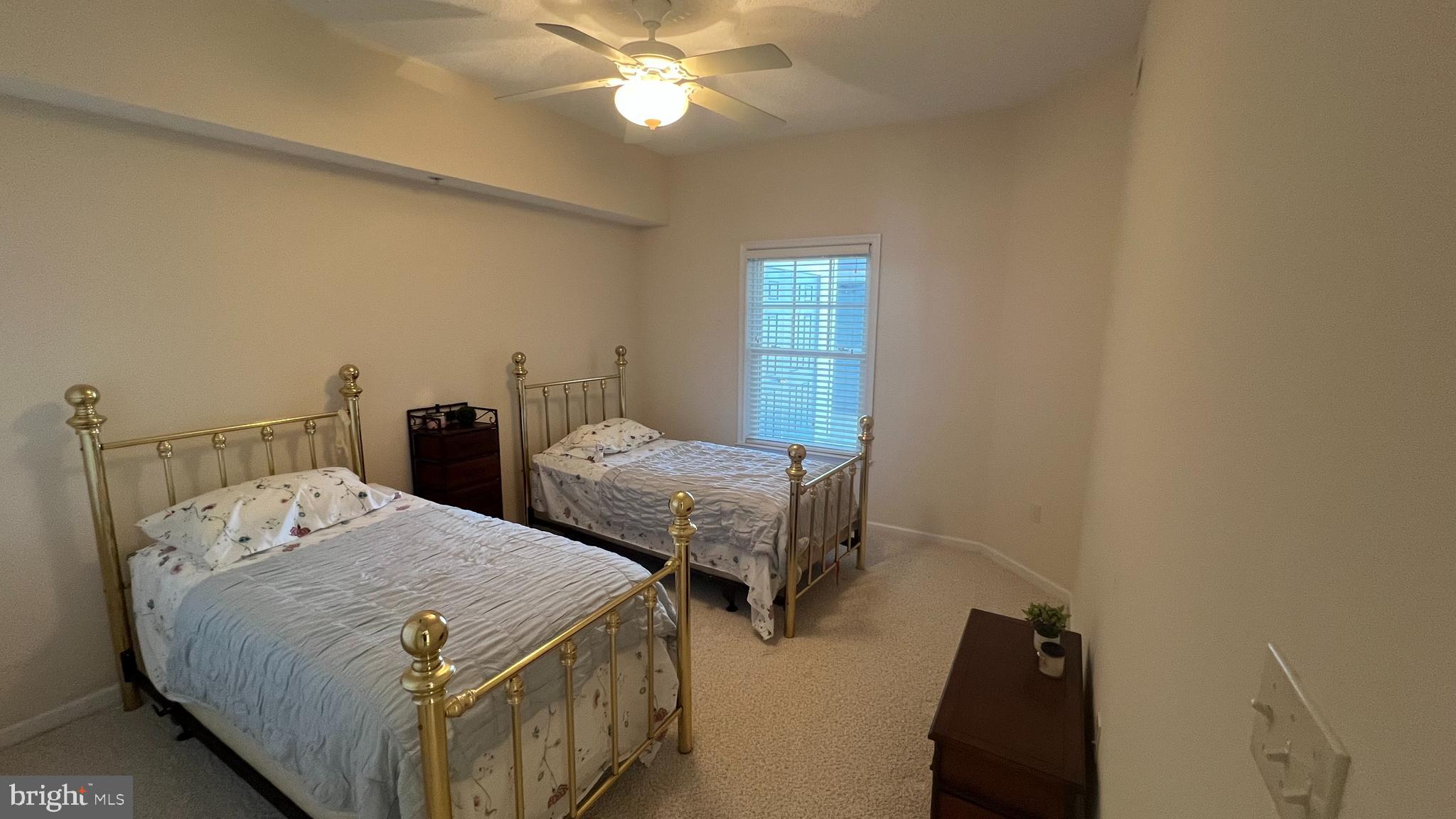 103 Williams Street, Unit 416 Crisfield, MD 21817 - Photo 31 of 38 a bedroom with two beds and a chandelier