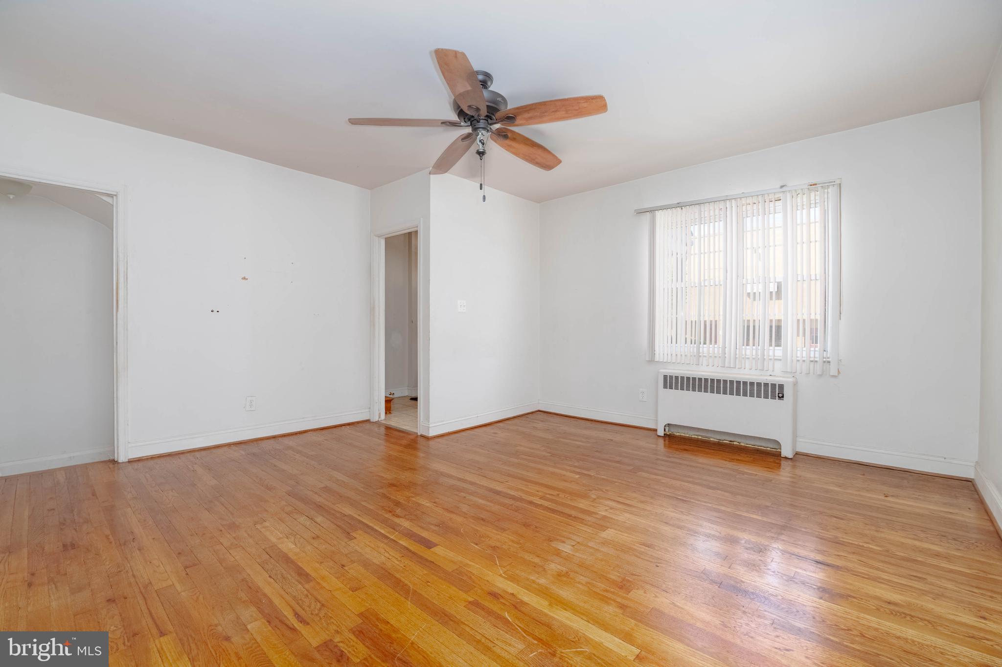 1517 North Potomac Street Baltimore, MD 21213 - Photo 5 of 44 a view of an empty room with wooden floor and a window