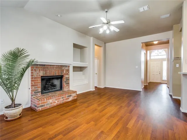 a view of a livingroom with wooden floor and a fireplace