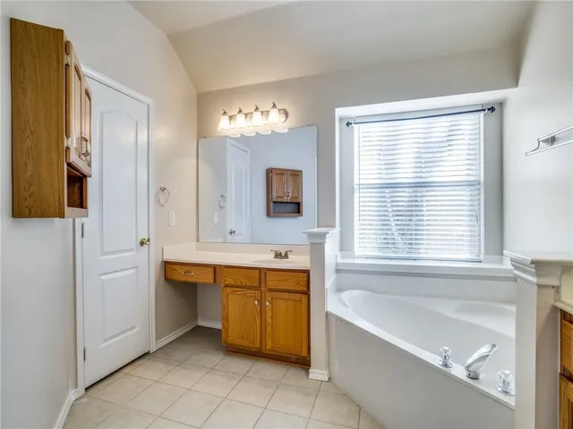 a bathroom with a tub sink and mirror