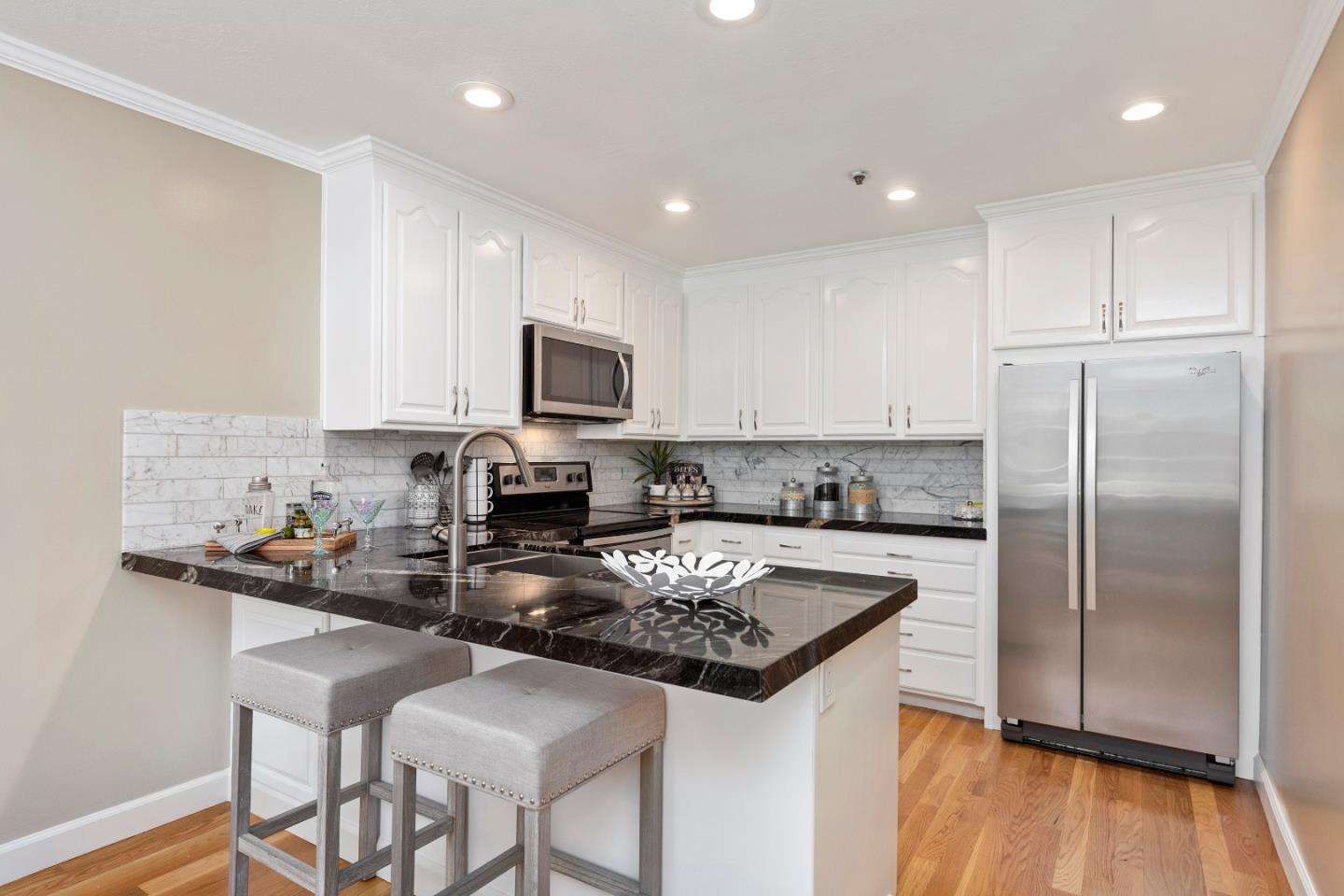 131 Giffin Road Los Altos, CA 94022 - Photo 11 of 29 a kitchen with stainless steel appliances granite countertop a refrigerator a stove a sink a microwave and white cabinets with wooden floor