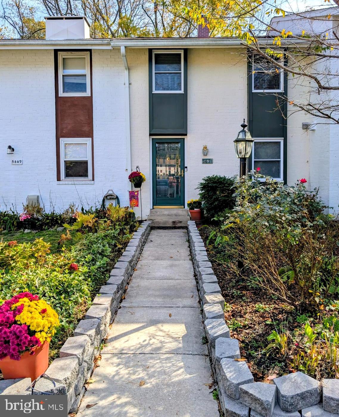 a front view of a house with a yard and flowers