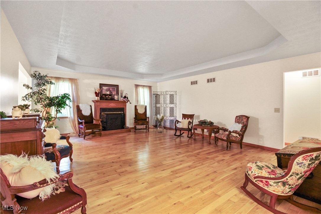 2632 Berry Road Akron, OH 44320 - Photo 7 of 39 Living room featuring a textured ceiling, a raised ceiling, and light hardwood / wood-style floors