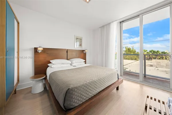 a bedroom with a bed and a large window