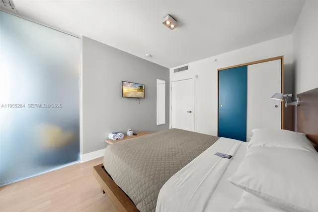 a bedroom with a bed and a painting on the wall