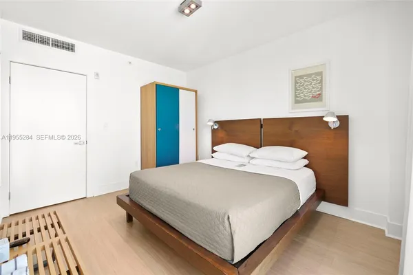 a bedroom with a bed and a night stand