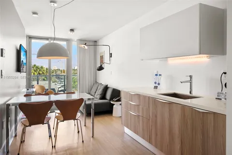 a kitchen with stainless steel appliances kitchen island granite countertop a sink a stove and a refrigerator