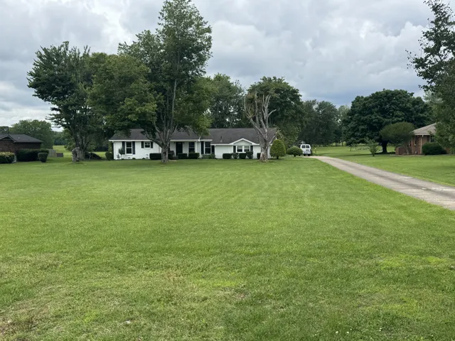 a front view of a house with a yard and trees