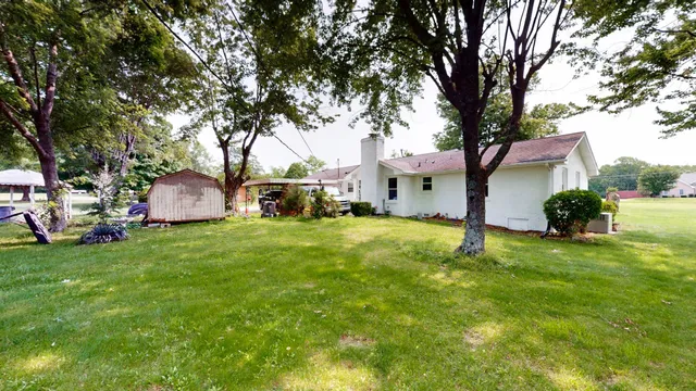a backyard of a house with table and chairs