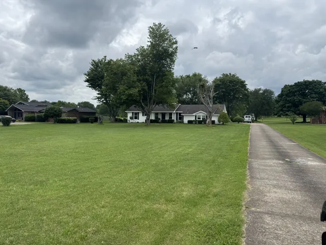 a view of a field with houses in the background