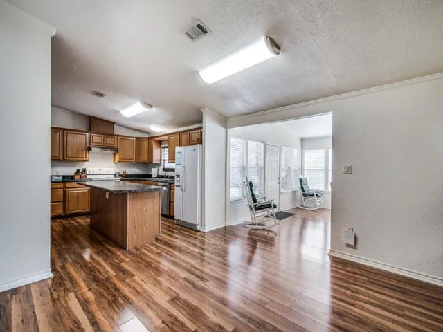 a kitchen with a refrigerator and white cabinets