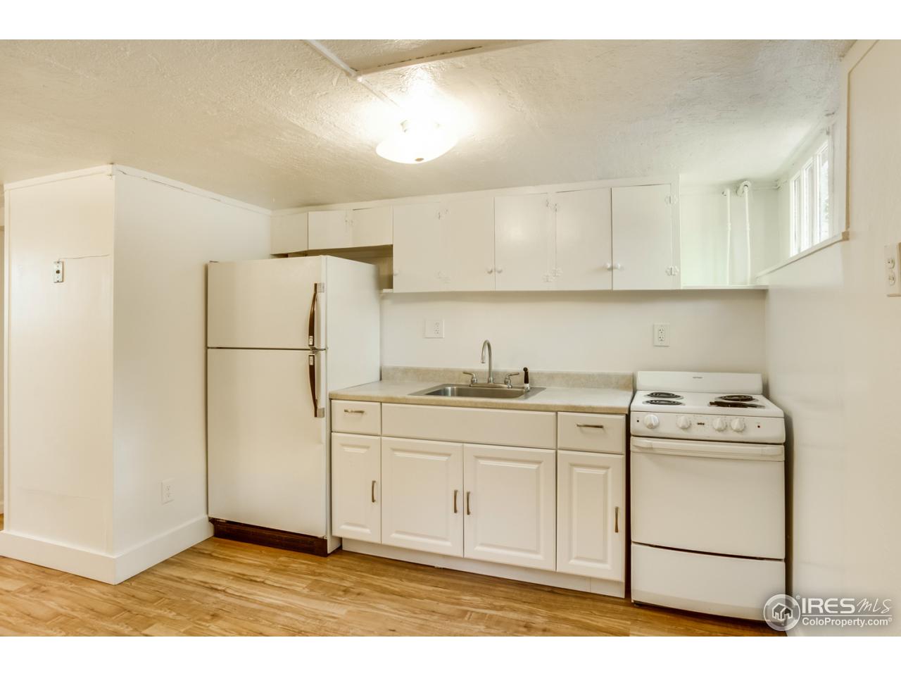 747 12th Street Boulder, CO 80302 - Photo 20 of 25 a kitchen with a sink a refrigerator a stove and white cabinets