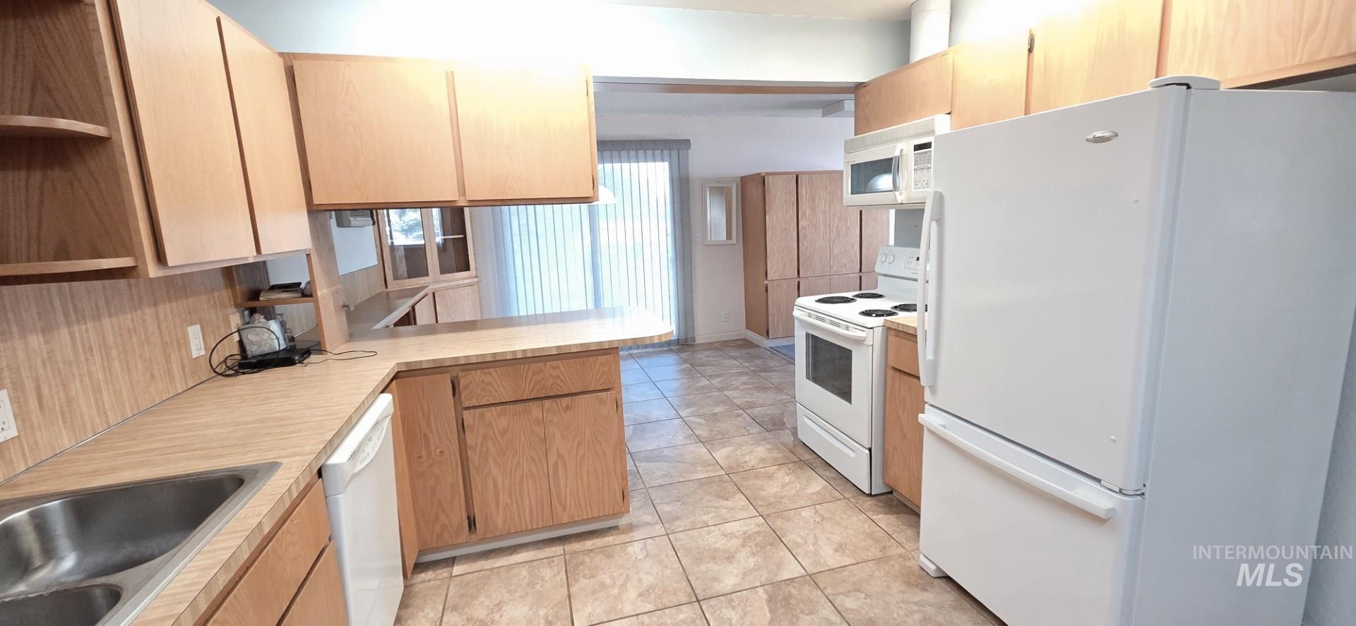 1902 Arlington Street Pomeroy, WA 99347 - Photo 15 of 27 Kitchen with white appliances, open shelves, light countertops, a peninsula, and light tile patterned floors
