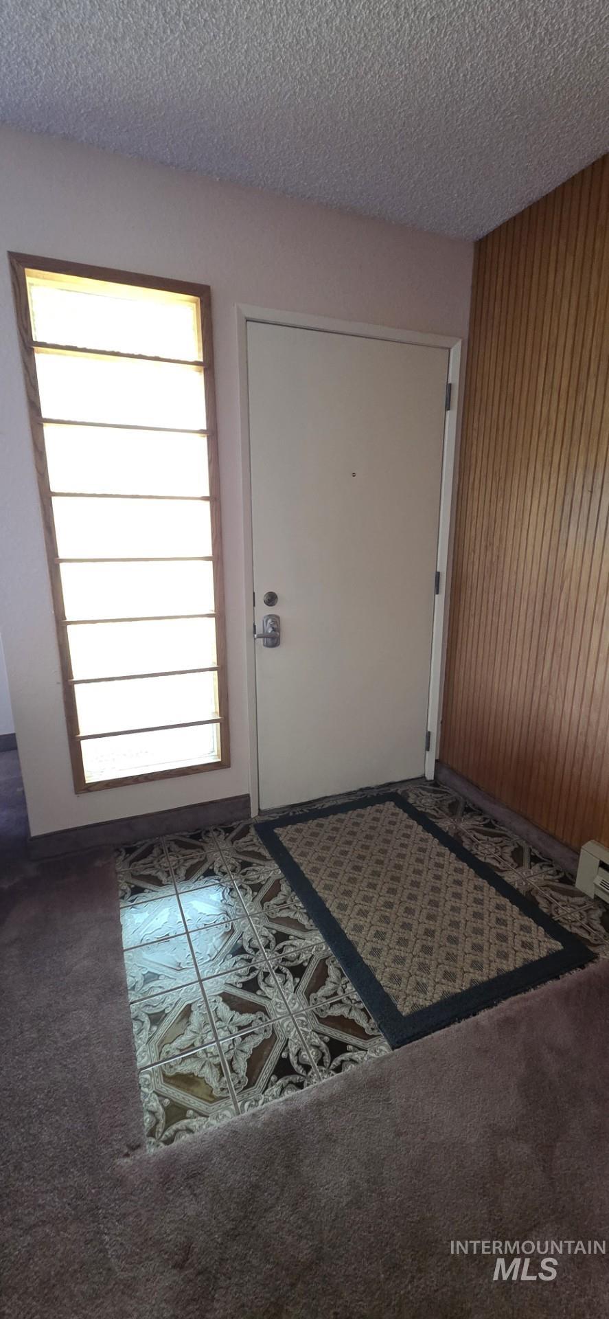 1902 Arlington Street Pomeroy, WA 99347 - Photo 18 of 27 Carpeted foyer with a textured ceiling and wood walls