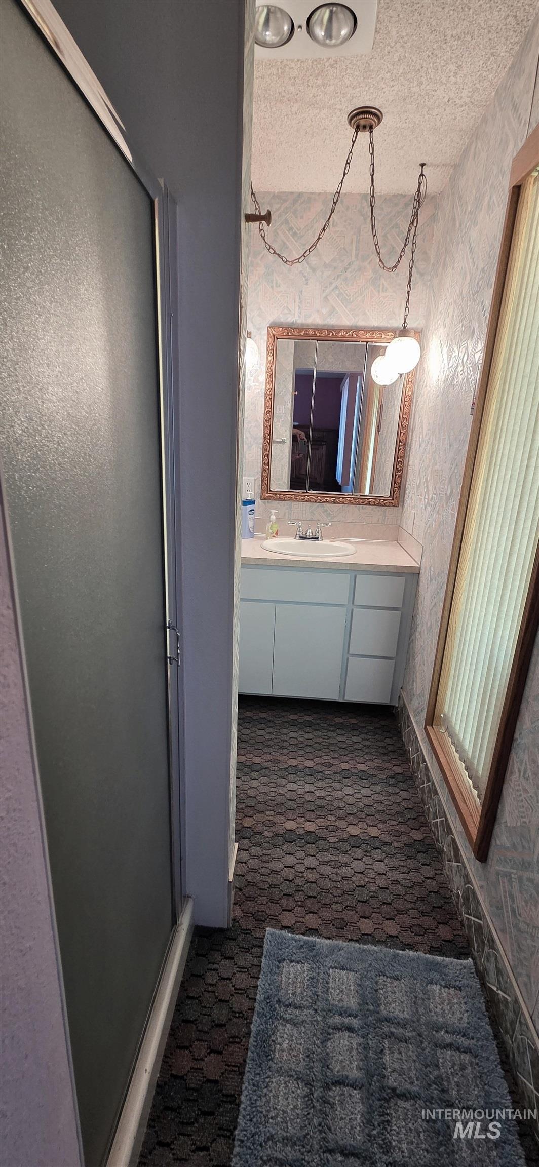 1902 Arlington Street Pomeroy, WA 99347 - Photo 23 of 27 Bathroom with vanity, a textured ceiling, and a stall shower