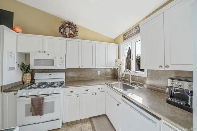 a kitchen with stainless steel appliances granite countertop a sink dishwasher and cabinets with wooden floor