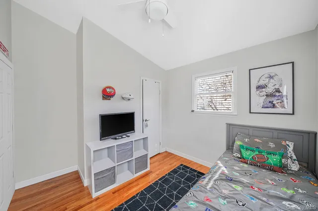 a bedroom with a bed and a flat tv screen on the dresser