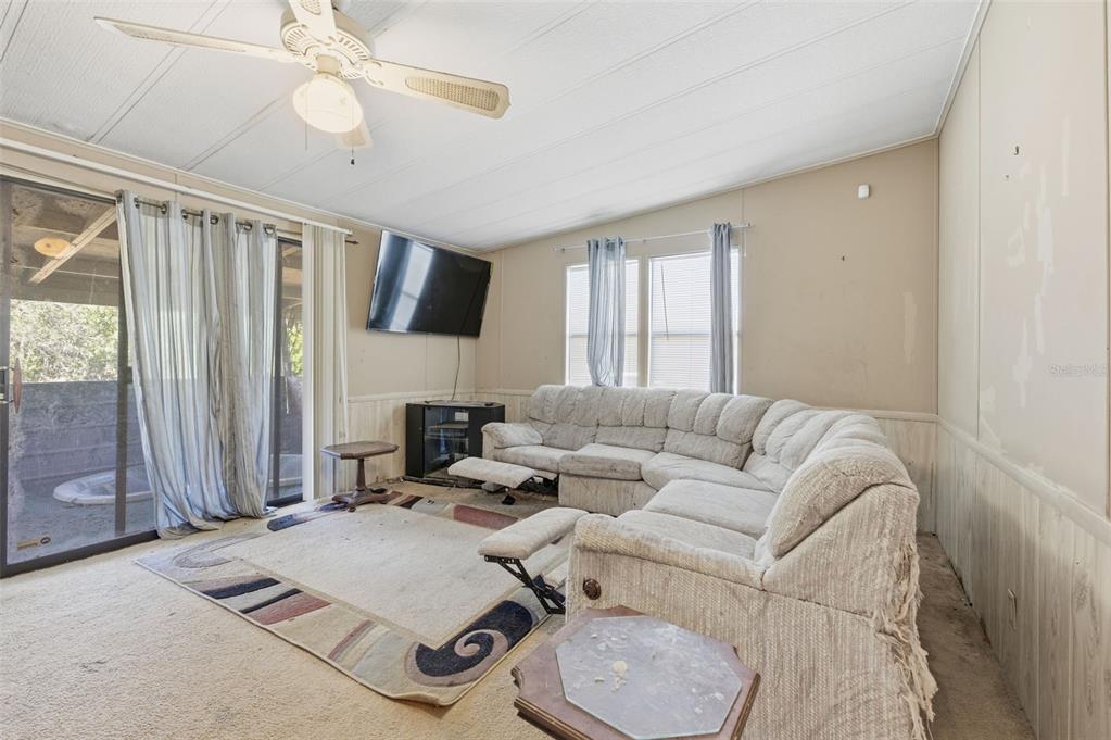 8045 Indian Trail Road Weeki Wachee, FL 34613 - Photo 25 of 49 a living room with furniture and a flat screen tv