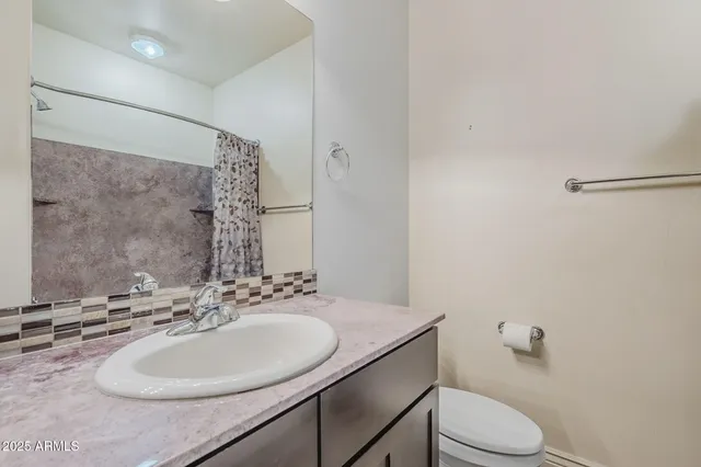 a bathroom with a sink toilet and a mirror