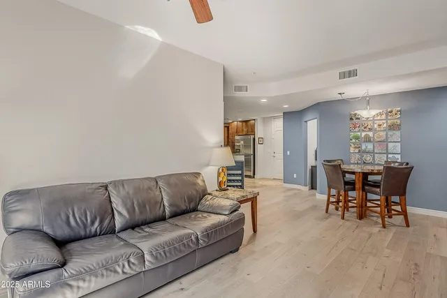 a living room with furniture and a dining table with kitchen view