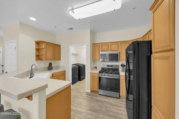 a kitchen with stainless steel appliances granite countertop a refrigerator and a sink