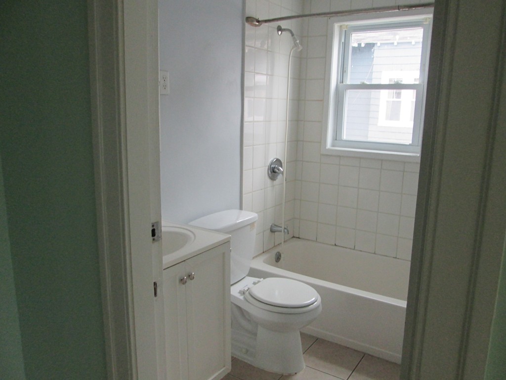 26 Sylvan Street Worcester, MA 01603 - Photo 21 of 27 a bathroom with a granite countertop toilet a sink a window and shower