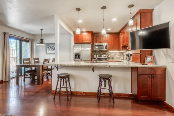a kitchen with a table chairs refrigerator microwave and cabinets