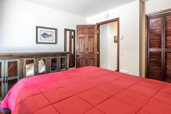 a large bedroom with a bed and a large mirror