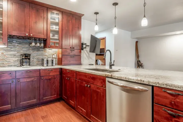 a kitchen with stainless steel appliances granite countertop wooden cabinets a sink and dishwasher
