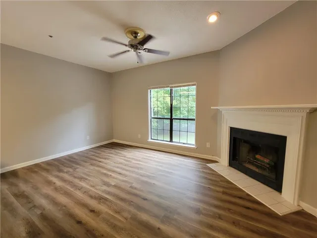 a view of empty room with wooden floor and fireplace
