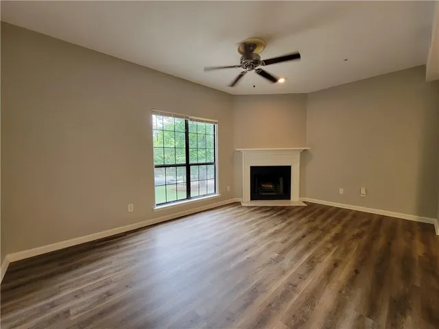a view of an empty room with a fireplace and a window
