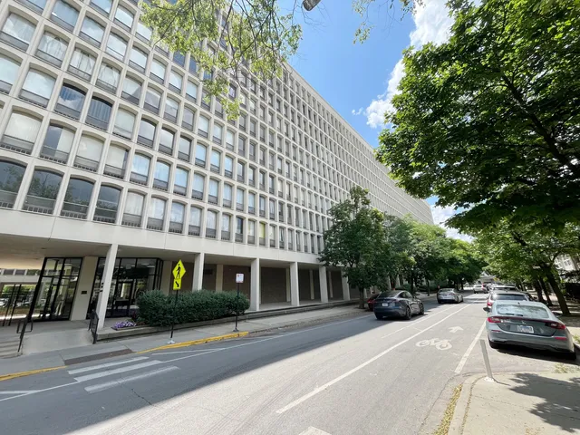 a view of a building and car parked on the road