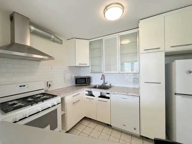 a kitchen with white cabinets and white appliances