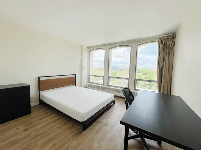 a bedroom with a bed and a large window