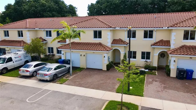 a front view of a house with a garden and parking