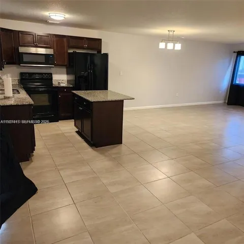 a kitchen with stainless steel appliances a sink a stove top oven a counter space and cabinets